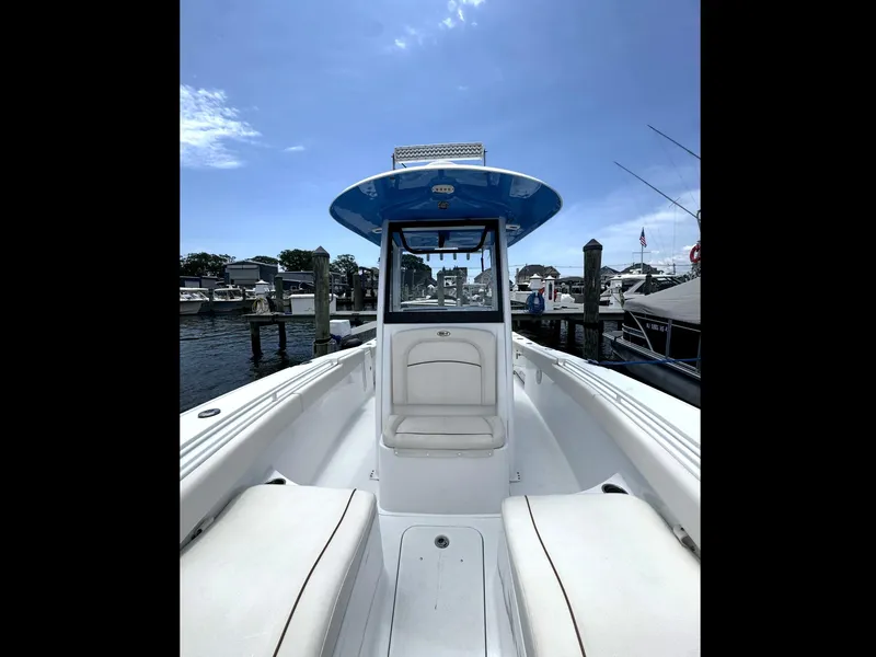 Slide: The Image of 2022 Sea Hunt Ultra 275 SE boat docked at marina under clear blue sky. - 43