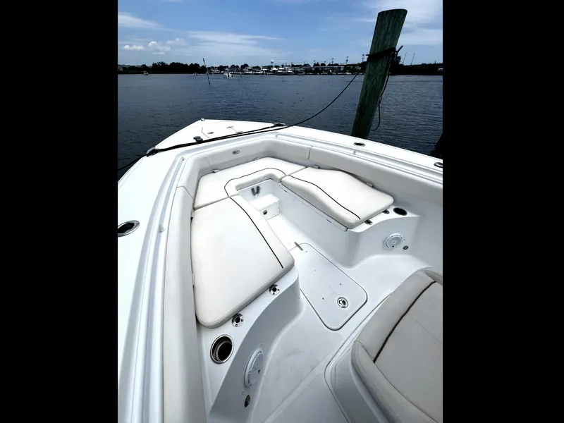 Slide: The Image of 2022 Sea Hunt Ultra 275 SE boat interior with white seating, docked by the water. - 46