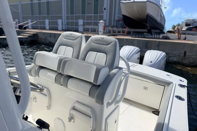 Slide: The Image of 2022 Regulator 28 boat with dual seats and twin outboard engines at dock. - 11