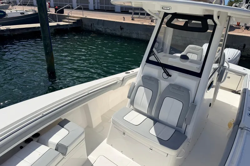 Slide: The Image of 2022 Regulator 28 boat interior with seating and helm, docked by the water. - 3