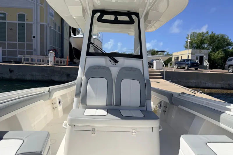 Slide: The Image of 2022 Regulator 28 boat interior with seating, docked at marina under clear blue sky. - 6