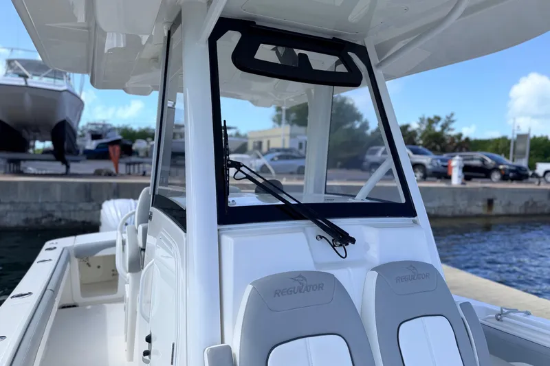 Slide: The Image of 2022 Regulator 28 boat at dock, showcasing helm and seating area. - 8