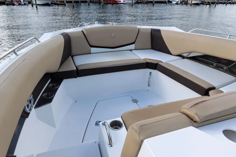 Slide: The Image of 2015 Cruisers Yachts 338 Bow Rider interior with beige seating, dockside view. - 10