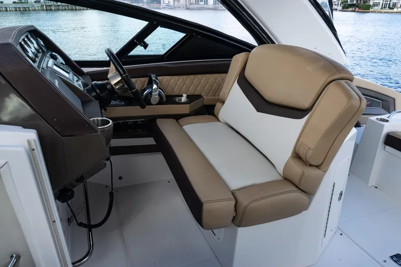 Slide: The Image of 2015 Cruisers Yachts 338 Bow Rider helm with Raymarine electronics and luxurious seating. - 15