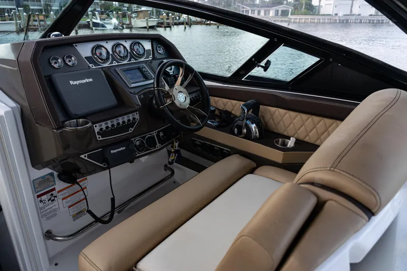 Slide: The Image of 2015 Cruisers Yachts 338 Bow Rider interior with beige seating, overlooking calm waters. - 16