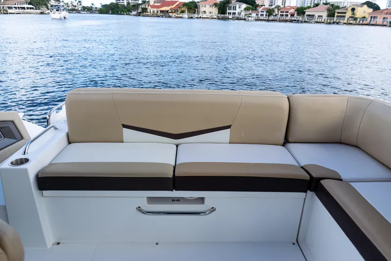 Slide: The Image of 2015 Cruisers Yachts 338 Bow Rider interior seating, featuring beige and white upholstery. - 17