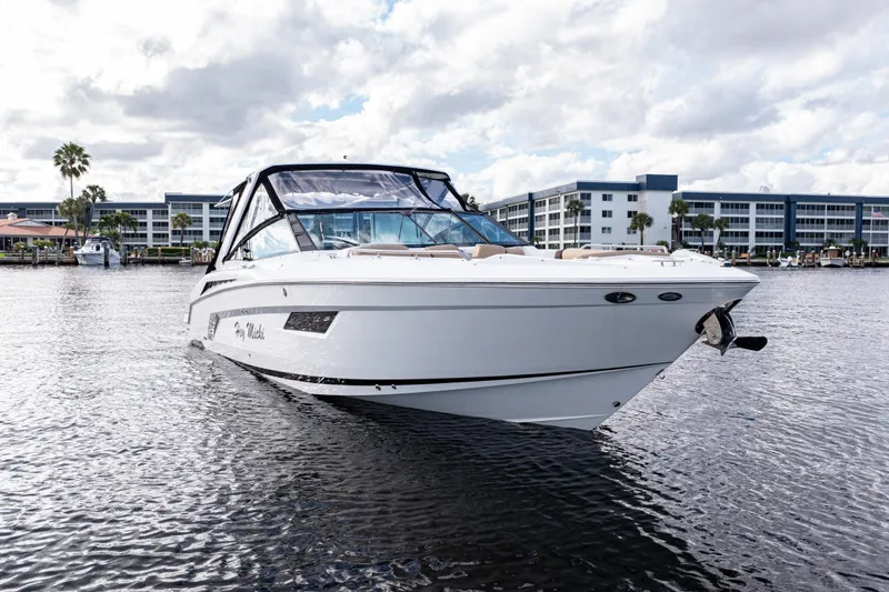 Slide: The Image of 2015 Cruisers Yachts 338 Bow Rider on water, modern design, marina backdrop. - 2