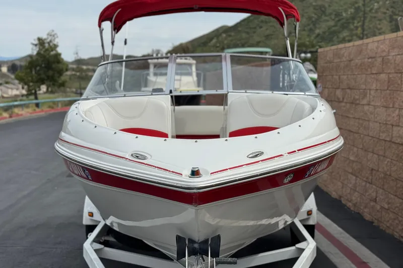 Slide: The Image of 2007 Ebbtide 180 SE boat with red accents, parked on a trailer. - 2