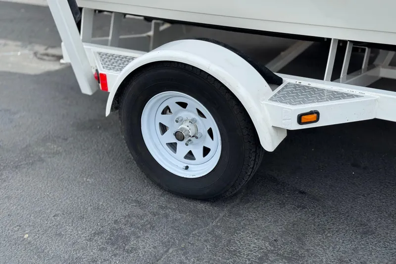 Slide: The Image of Trailer wheel of a 2007 Ebbtide 180 SE boat on pavement. - 24