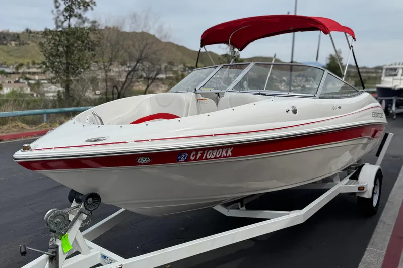 Slide: The Image of 2007 Ebbtide 180 SE boat with red accents on a trailer, parked outdoors. - 3