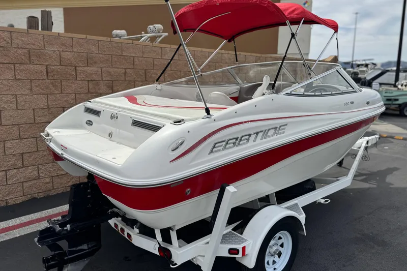 Slide: The Image of 2007 Ebbtide 180 SE boat with red accents on a trailer, parked outdoors. - 5