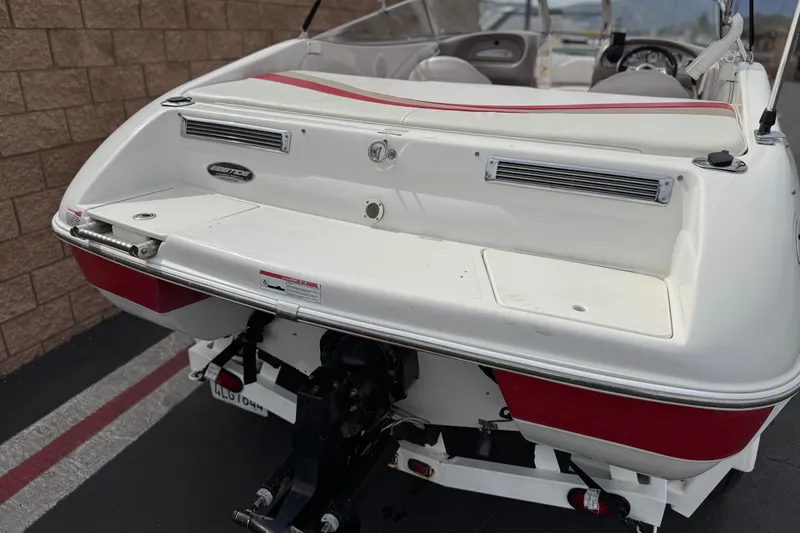Slide: The Image of 2007 Ebbtide 180 SE boat rear view, showcasing white and red design with seating area. - 6