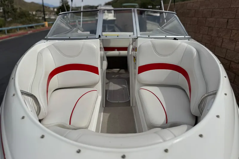 Slide: The Image of 2007 Ebbtide 180 SE boat interior with white and red seating, docked outdoors. - 9