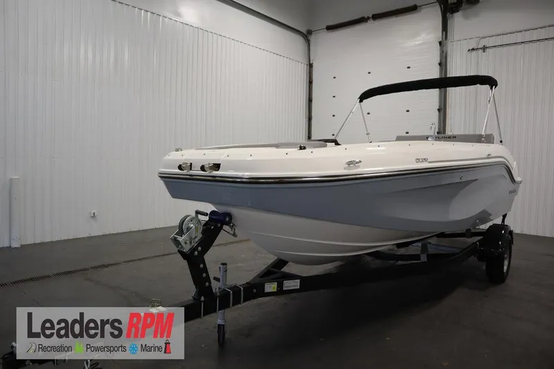 Slide: The Image of 2024 Bayliner 2050 DX boat on trailer in indoor showroom. - 1