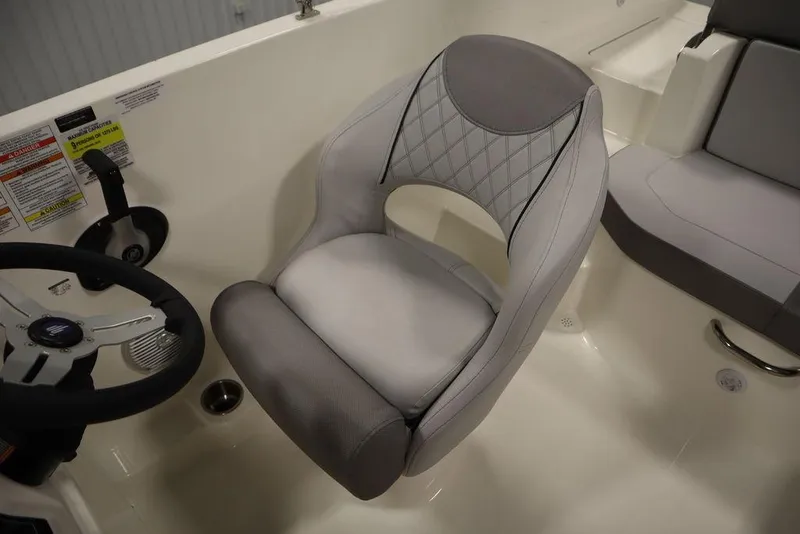 Slide: The Image of 2024 Bayliner 2050 DX boat interior with gray captain's seat and steering wheel. - 30