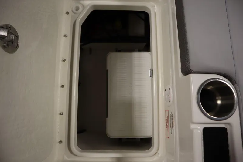 Slide: The Image of 2024 Bayliner 2050 DX storage compartment with cup holder and seating area. - 49