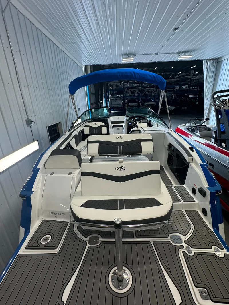 Slide: The Image of 2018 Monterey 258 Super Sport boat with sleek interior and blue canopy in showroom. - 25