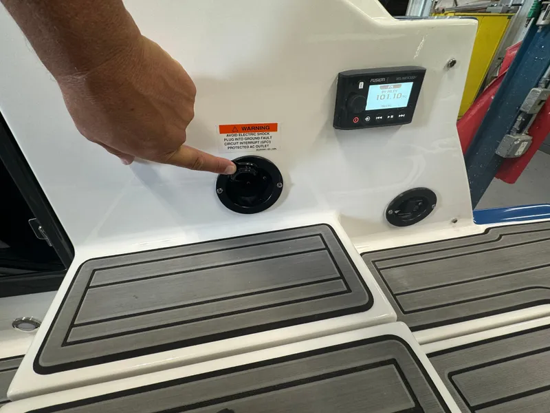 Slide: The Image of Close-up of a 2018 Monterey 258 Super Sport boat dashboard with a hand pointing at a control. - 26