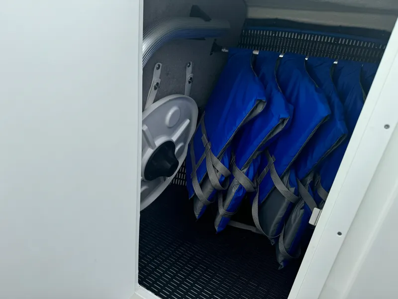 Slide: The Image of Storage compartment with blue life jackets on a 2018 Monterey 258 Super Sport boat. - 38