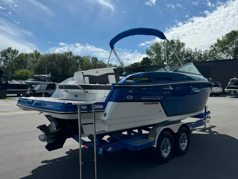 Slide: The Image of 2018 Monterey 258 Super Sport boat on trailer, blue and white, parked outdoors. - 5
