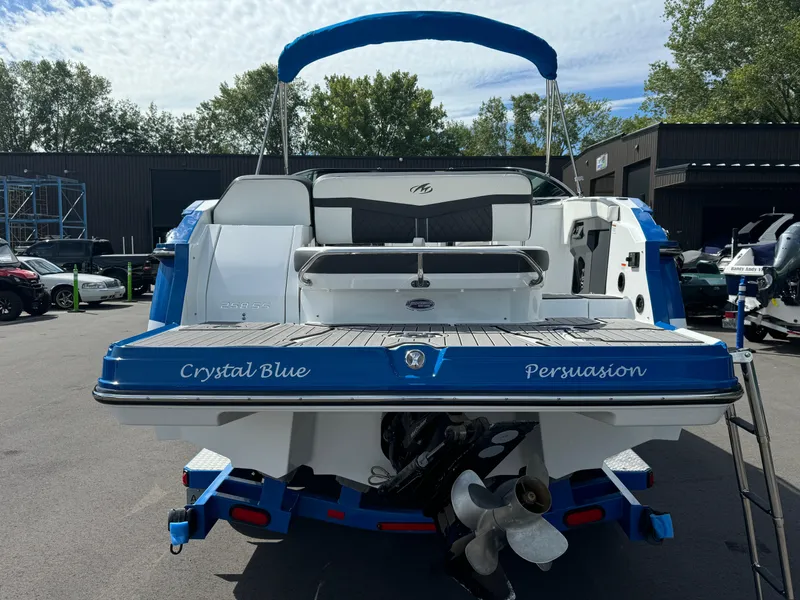 Slide: The Image of 2018 Monterey 258 Super Sport boat, rear view, blue and white design, parked outdoors. - 6