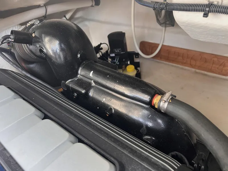 Slide: The Image of Engine compartment of 2019 Cruisers Yachts 338 Bow Rider, showing black components and hoses. - 49