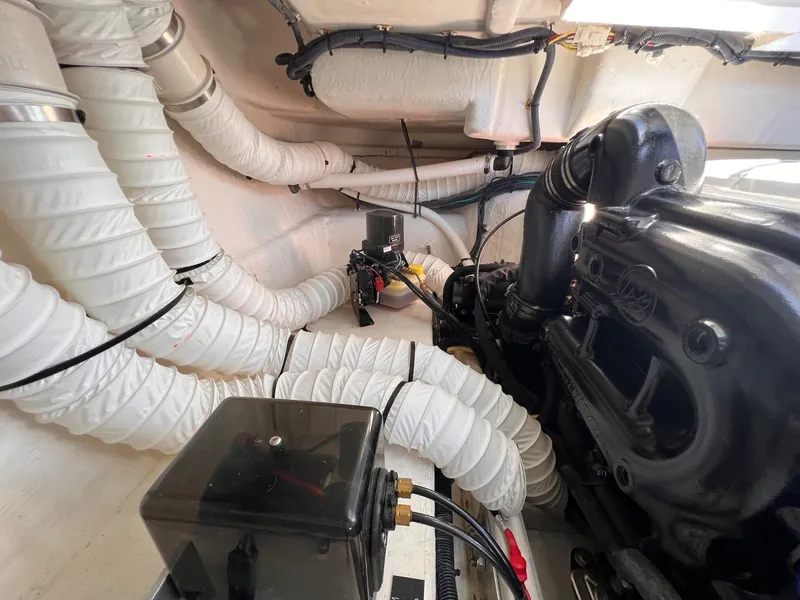 Slide: The Image of Engine compartment of 2019 Cruisers Yachts 338 Bow Rider with visible hoses and components. - 51