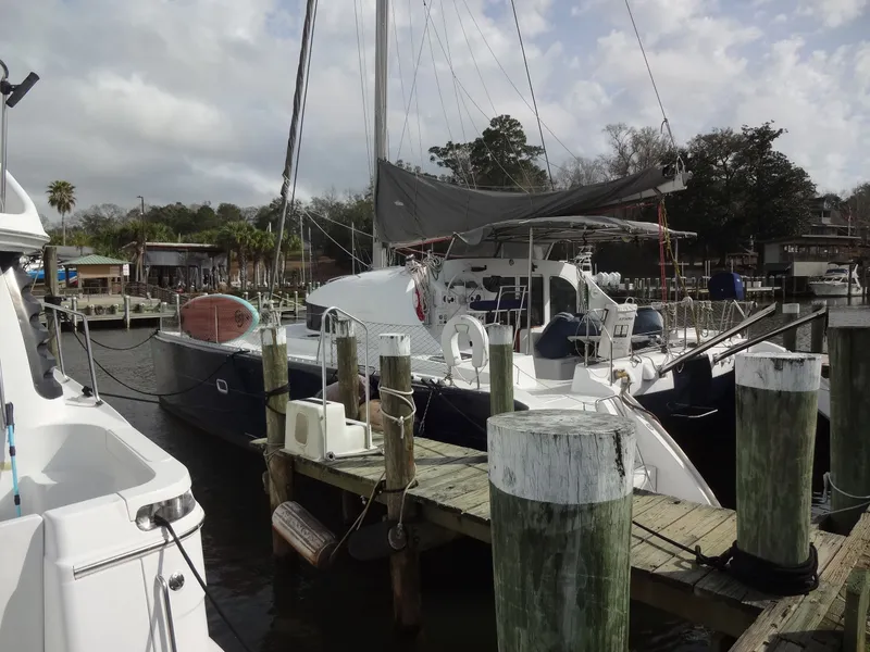Slide: The Image of 2003 Lagoon 410 catamaran docked on a sunny day. - 10