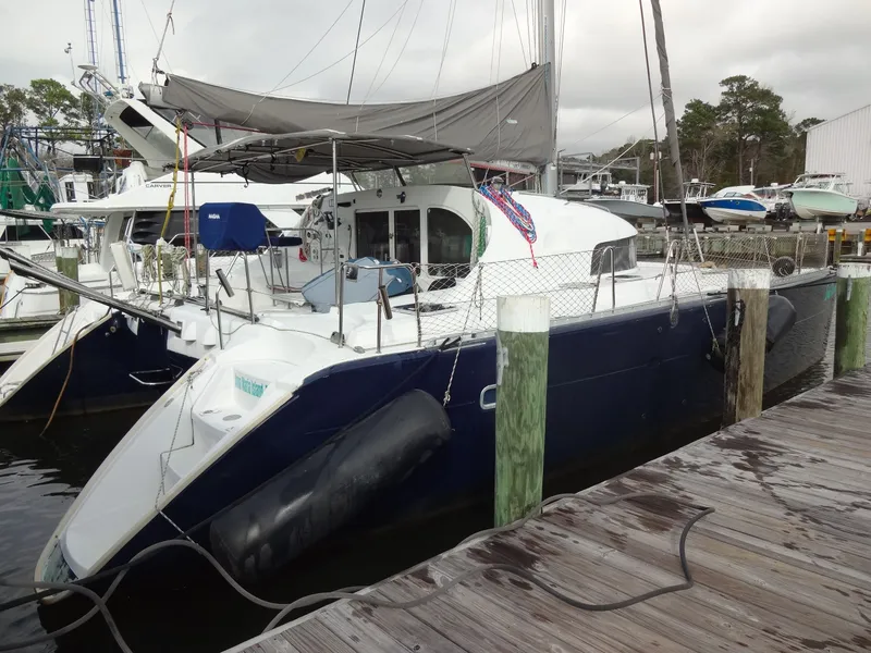 Slide: The Image of 2003 Lagoon 410 catamaran docked at marina. - 6