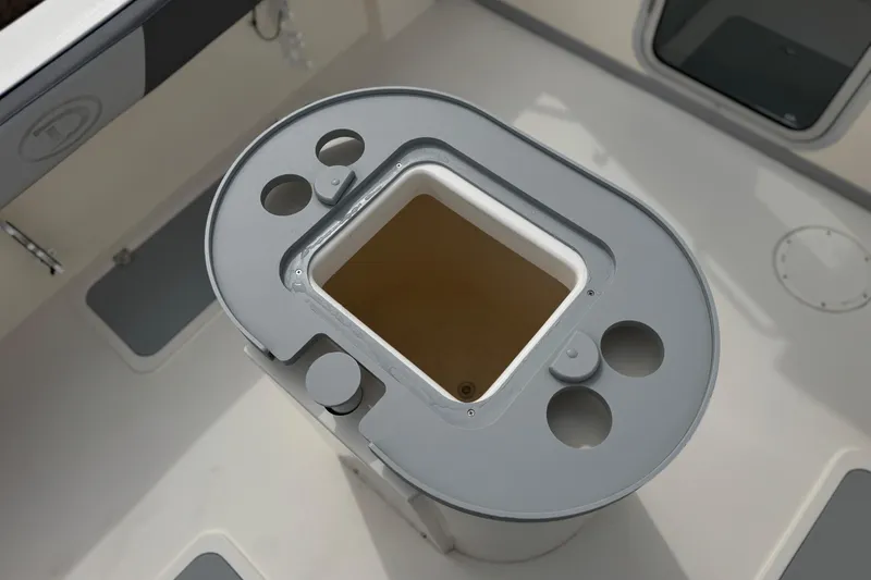 Slide: The Image of 2023 Defiance 220 Admiral EX boat interior with storage compartment and cup holders. - 15