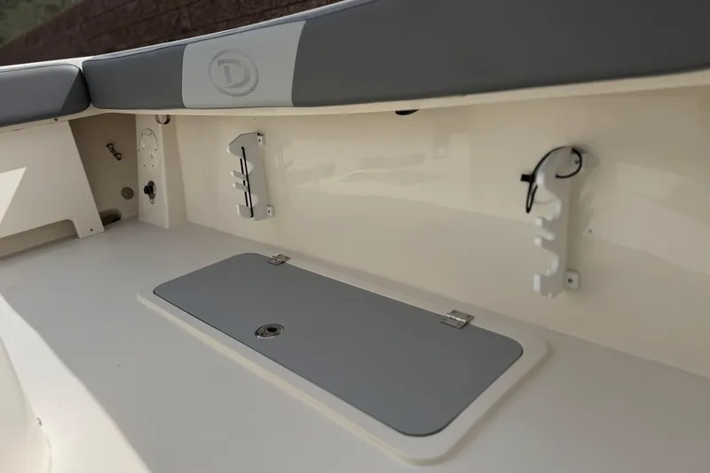 Slide: The Image of 2023 Defiance 220 Admiral EX boat interior with storage compartment and rod holders. - 16