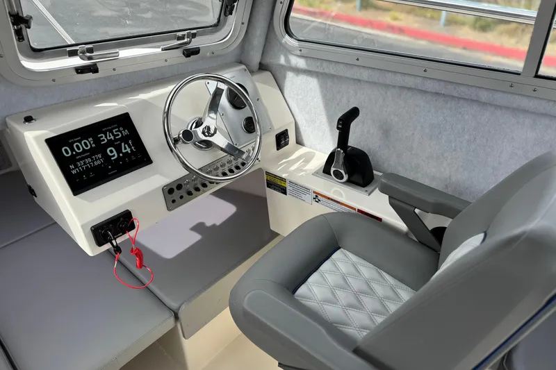 Slide: The Image of 2023 Defiance 220 Admiral EX boat cockpit with steering wheel and navigation display. - 25