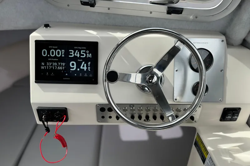 Slide: The Image of 2023 Defiance 220 Admiral EX dashboard with steering wheel and GPS display. - 26
