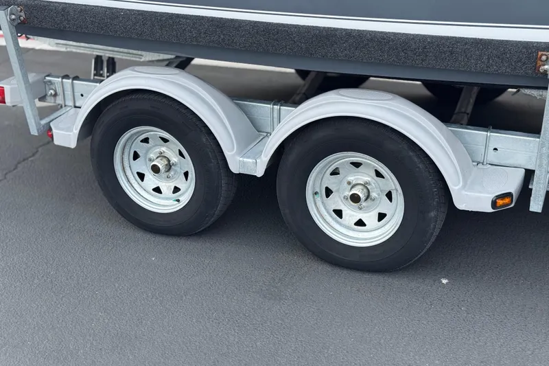 Slide: The Image of Trailer wheels of 2023 Defiance 220 Admiral EX boat on pavement. - 37