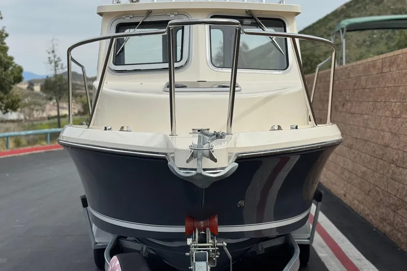 Slide: The Image of 2023 Defiance 220 Admiral EX boat on trailer, front view, parked outdoors. - 4