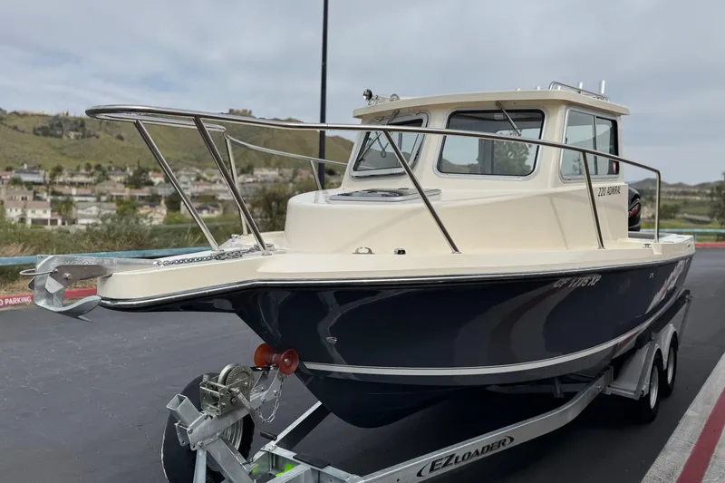 Slide: The Image of 2023 Defiance 220 Admiral EX boat on trailer, parked outdoors. - 5