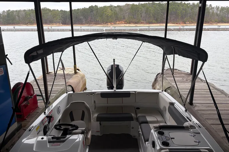 Slide: The Image of 2021 Tahoe 1950 boat docked at a serene lakeside marina. - 2