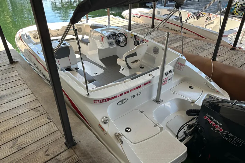 Slide: The Image of 2021 Tahoe 1950 boat docked, featuring spacious seating and Mercury Pro XS engine. - 2