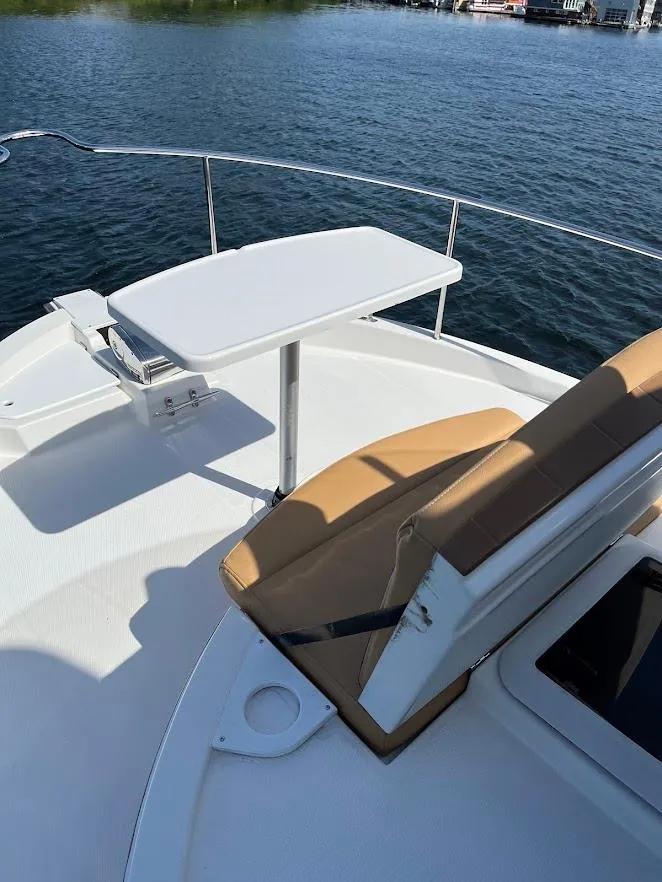 Slide: The Image of 2013 Ranger Tugs R-31 CB boat deck with seating and table, overlooking calm water. - 10