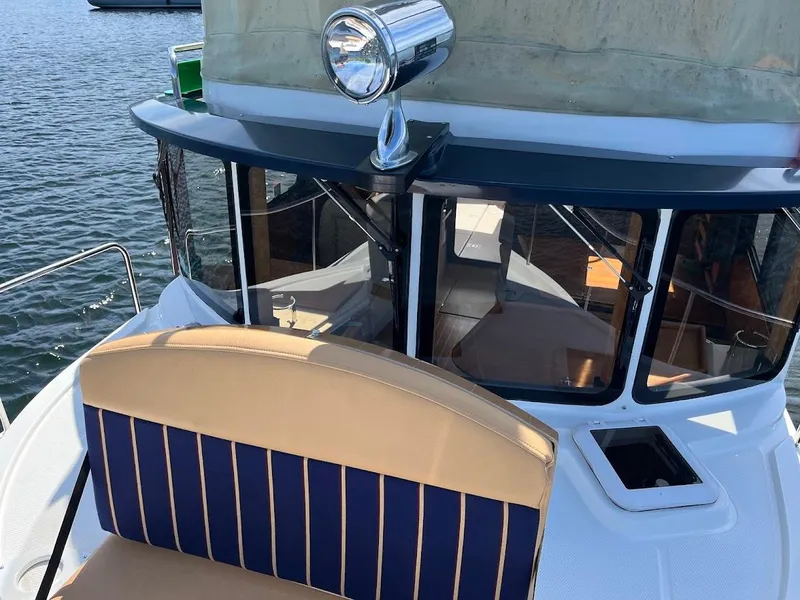 Slide: The Image of 2013 Ranger Tugs R-31 CB boat with striped seating, docked on calm water. - 12