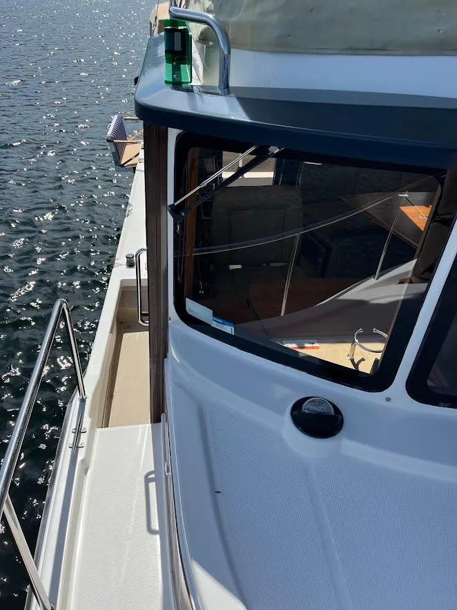 Slide: The Image of 2013 Ranger Tugs R-31 CB boat on water, showcasing deck and cabin details. - 13