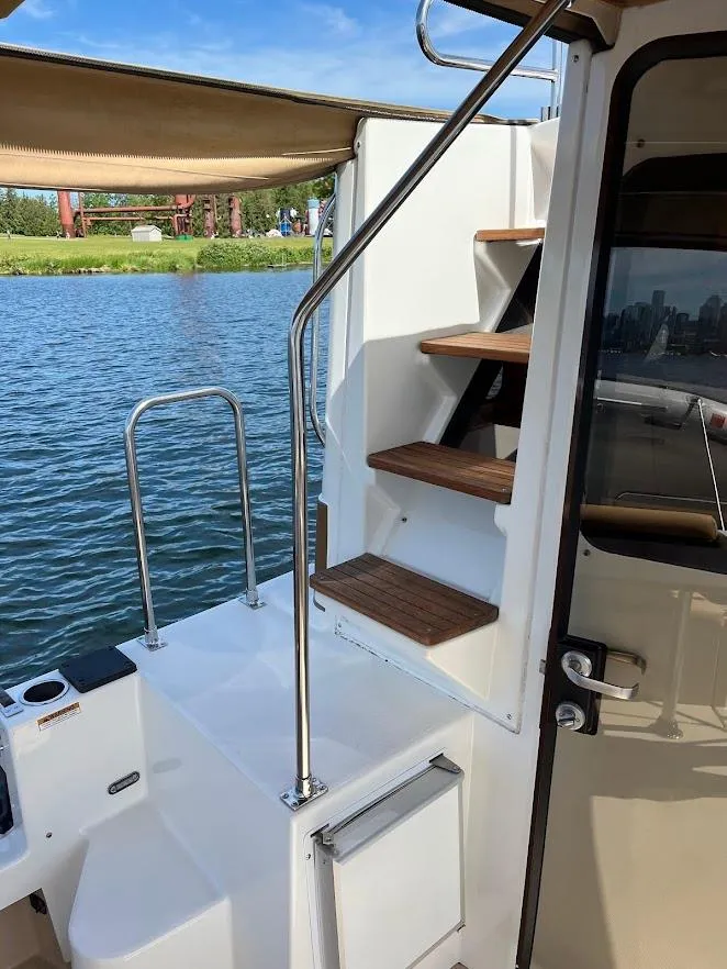 Slide: The Image of 2013 Ranger Tugs R-31 CB boat with wooden steps and water view. - 14