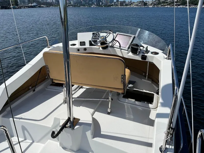 Slide: The Image of 2013 Ranger Tugs R-31 CB boat helm with tan seating, steering wheel, and navigation equipment. - 16