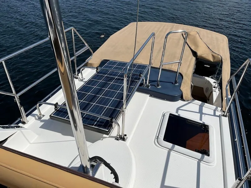 Slide: The Image of 2013 Ranger Tugs R-31 CB boat deck with solar panels and railing, on calm water. - 19