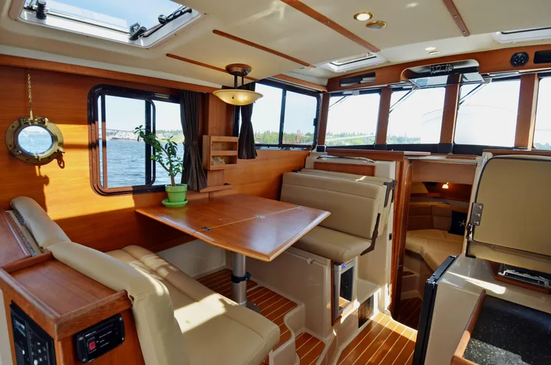 Slide: The Image of Interior of 2013 Ranger Tugs R-31 CB, featuring cozy seating and wooden accents. - 22