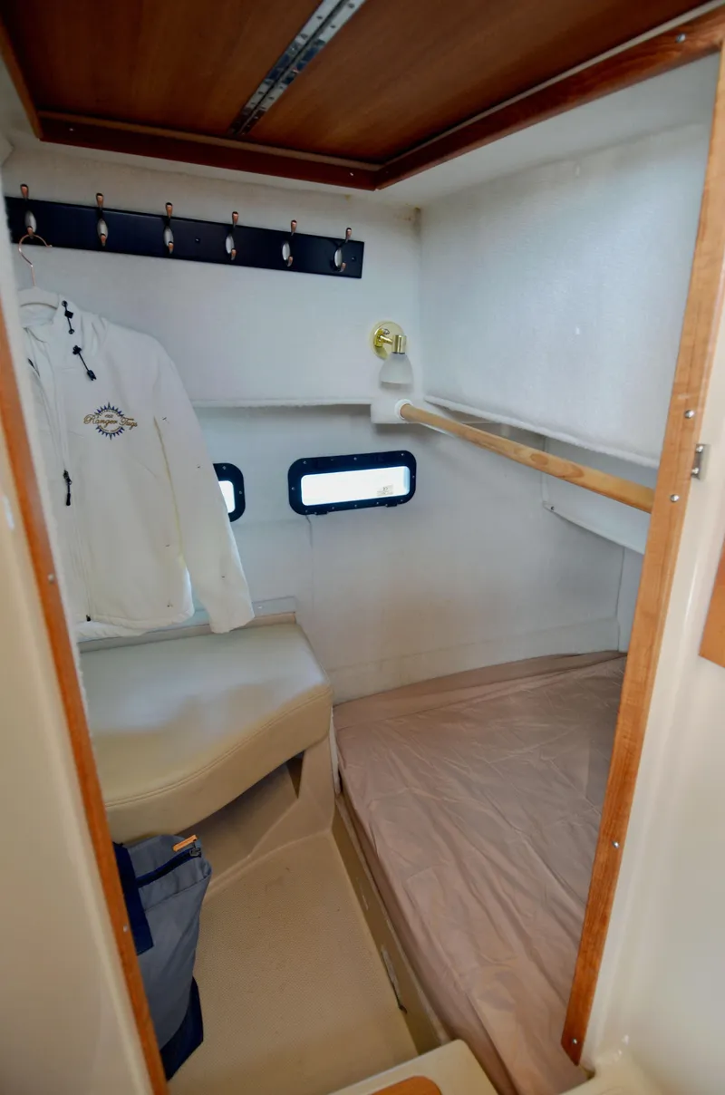 Slide: The Image of 2013 Ranger Tugs R-31 CB cabin interior with bed and coat hooks. - 27