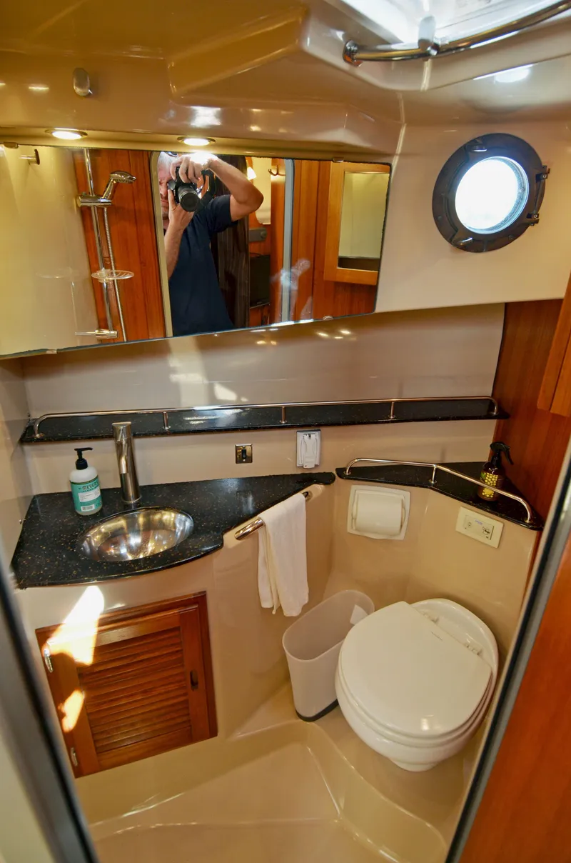 Slide: The Image of 2013 Ranger Tugs R-31 CB bathroom with sink, toilet, and porthole window. - 29