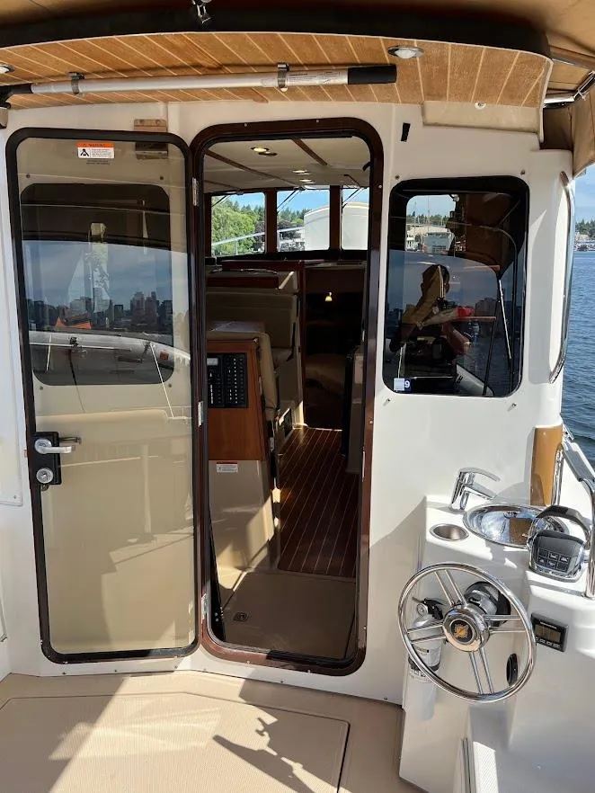 Slide: The Image of 2013 Ranger Tugs R-31 CB boat interior with open door, showcasing cabin and helm. - 4