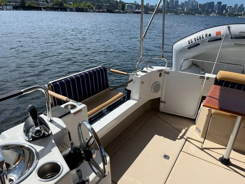 Slide: The Image of 2013 Ranger Tugs R-31 CB boat deck with seating, steering wheel, and water view. - 6