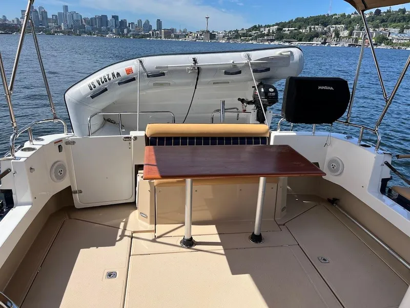 Slide: The Image of 2013 Ranger Tugs R-31 CB boat deck with table, city skyline in background. - 7